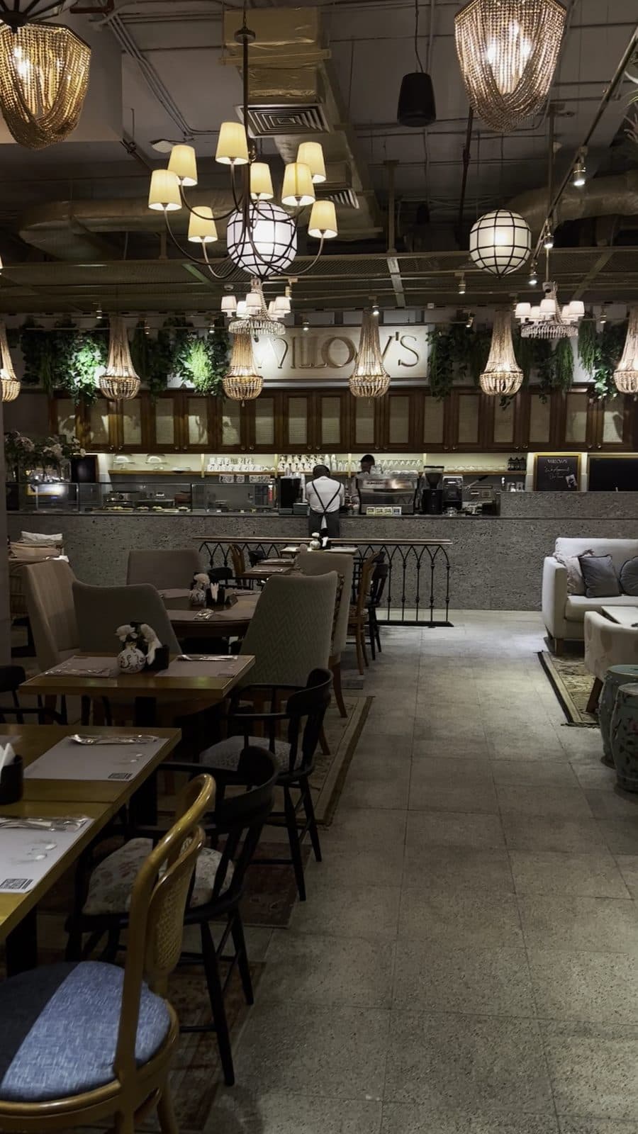 The interior dining room at Willow's Arkan Plaza, with chandeliers hanging over the tables.